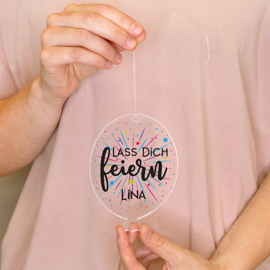 Personalisierter Acrylanhänger in Luftballonform mit Aufdruck Lass dich feiern und Name Lina in den Händen gehalten
