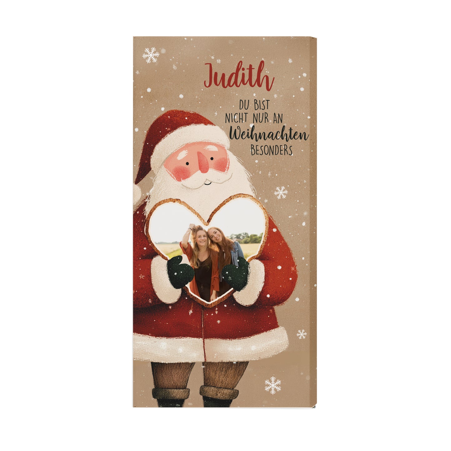 Weihnachts-Schokolade mit Herzfoto und Namensdruck. Die Verpackung zeigt einen Weihnachtsmann mit rotem Mantel, weißen Schneeflocken und dem Namen „Judith“. Das Foto ist in das Herz integriert. Die naturbraune Farbgebung der Verpackung sorgt für einen modernen und warmen Look – perfekte Geschenkidee für die Feiertage.