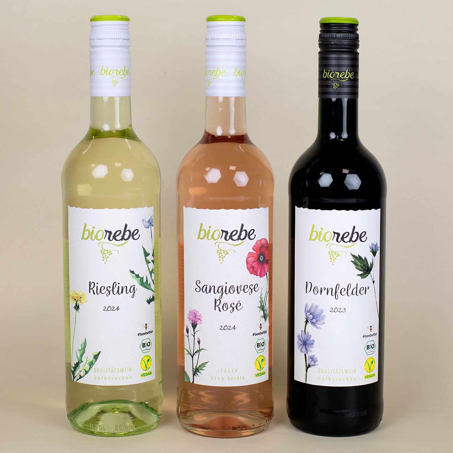 Drei Flaschen Biorebe Wein – Riesling, Sangiovese Rosé und Dornfelder – Vorderseite mit Blumen-Etiketten