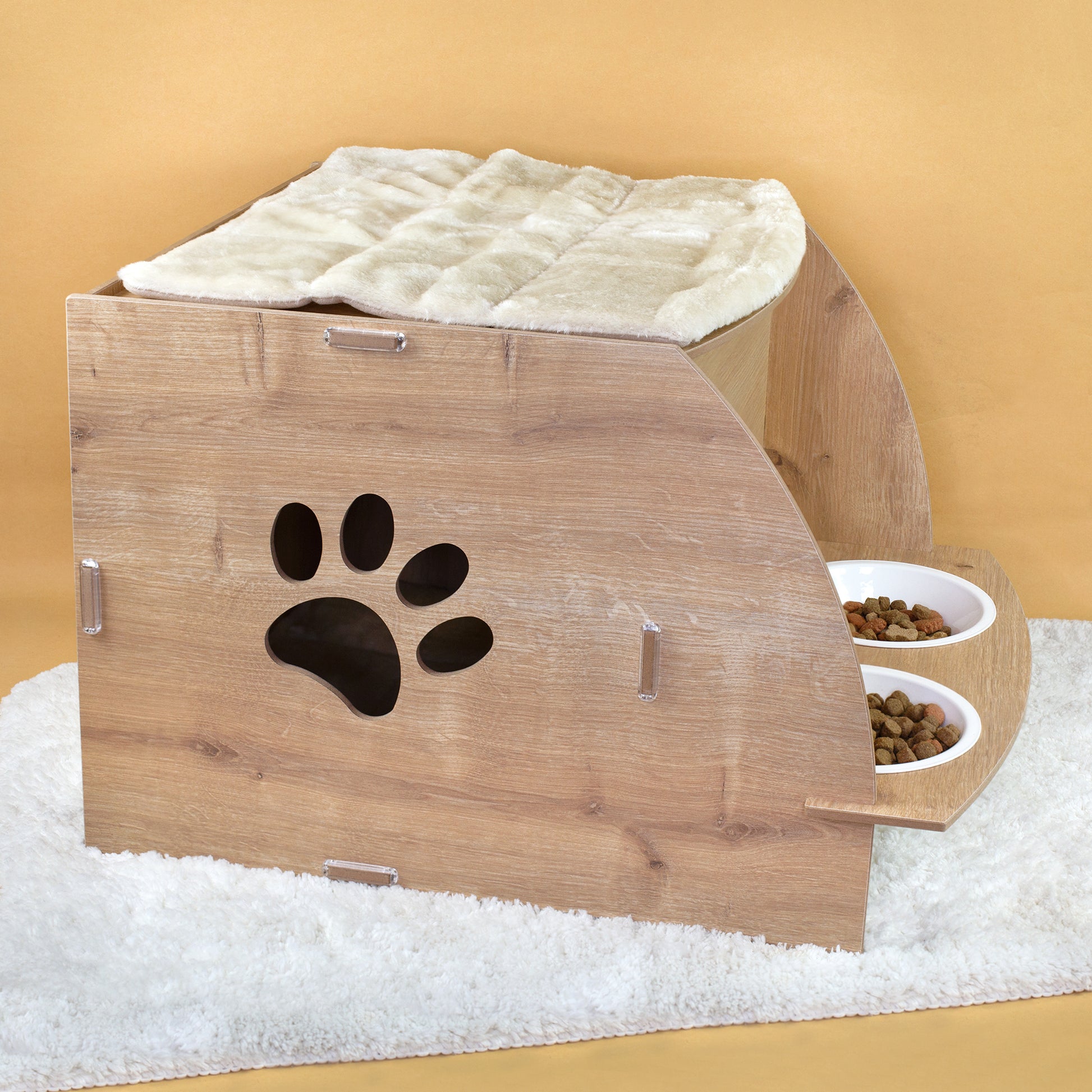 Rückseite des Katzenhauses in Eiche-Optik mit Pfotenabdruck-Ausschnitt, oberem Kissen und seitlicher Futterstation mit zwei Näpfen