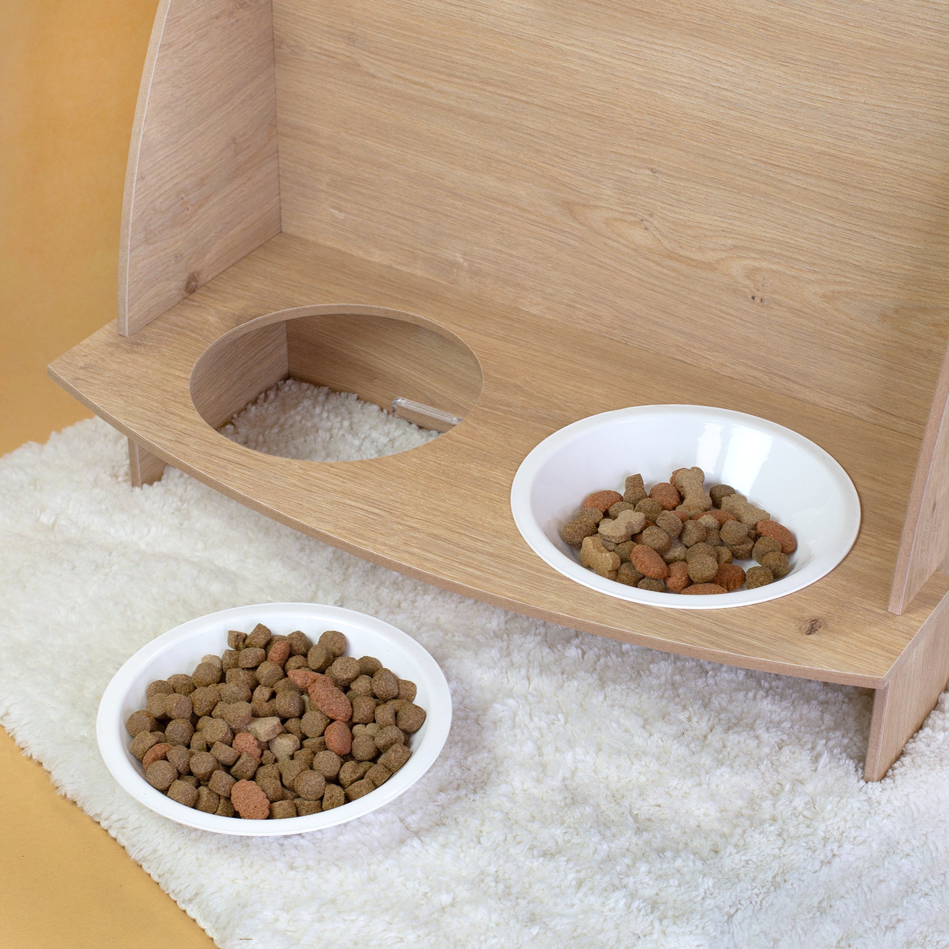 Detailansicht der Futterstation mit zwei Näpfen und Trockenfutter am Katzenhaus aus Holz