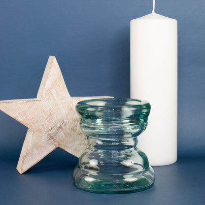 Handgearbeiteter Glas Kerzenhalter mit Holzstern und weißer Kerze vor blauem Hintergrund