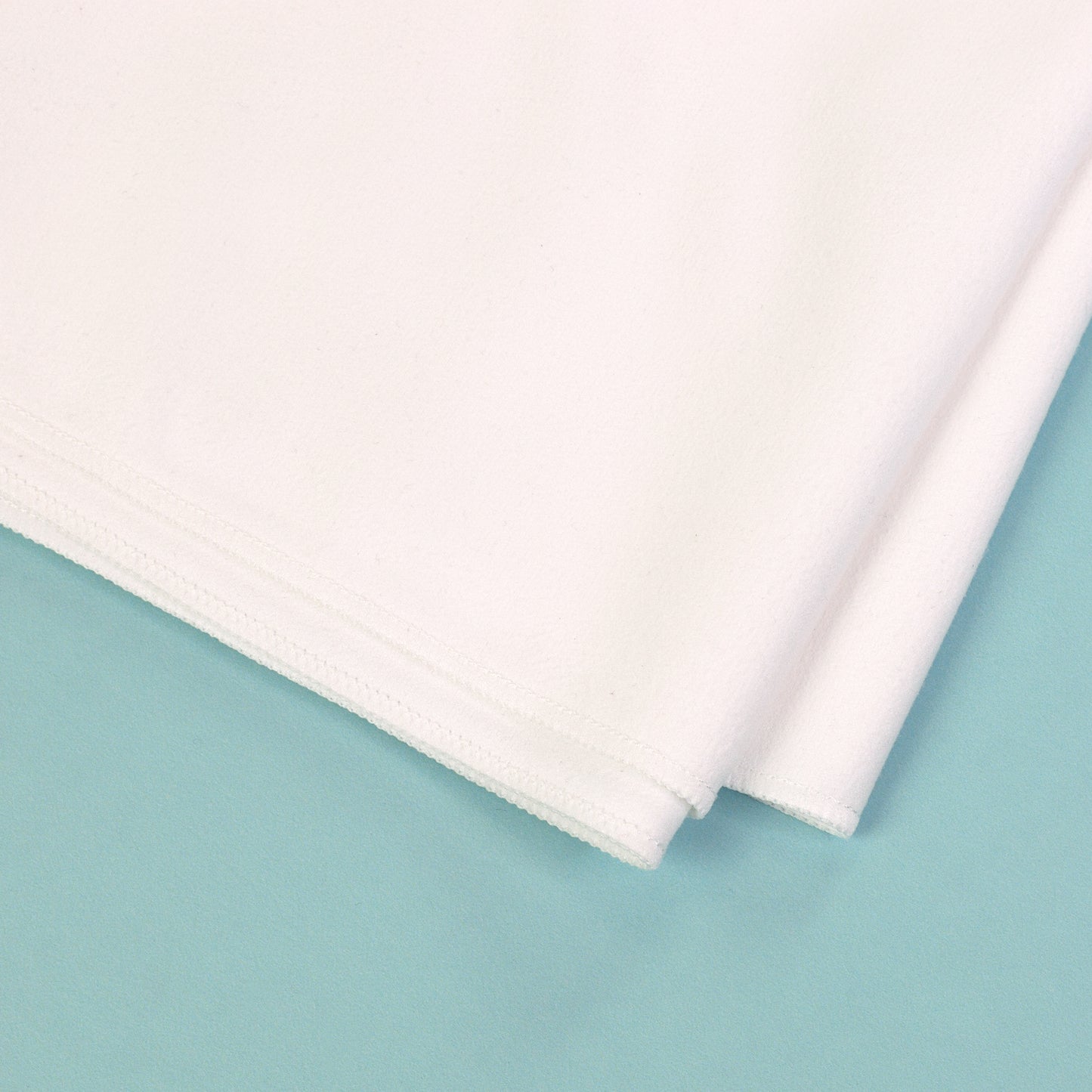 Detailaufnahme von Material und Naht eines weißen schnelltrocknenden Sporthandtuchs