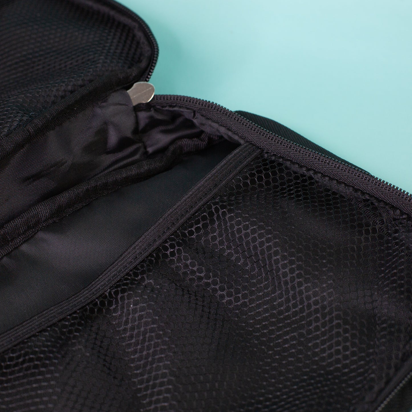 Detailansicht der Innenaufteilung mit schwarzem Netzfach und Reißverschluss der aufklappbaren Waschtasche