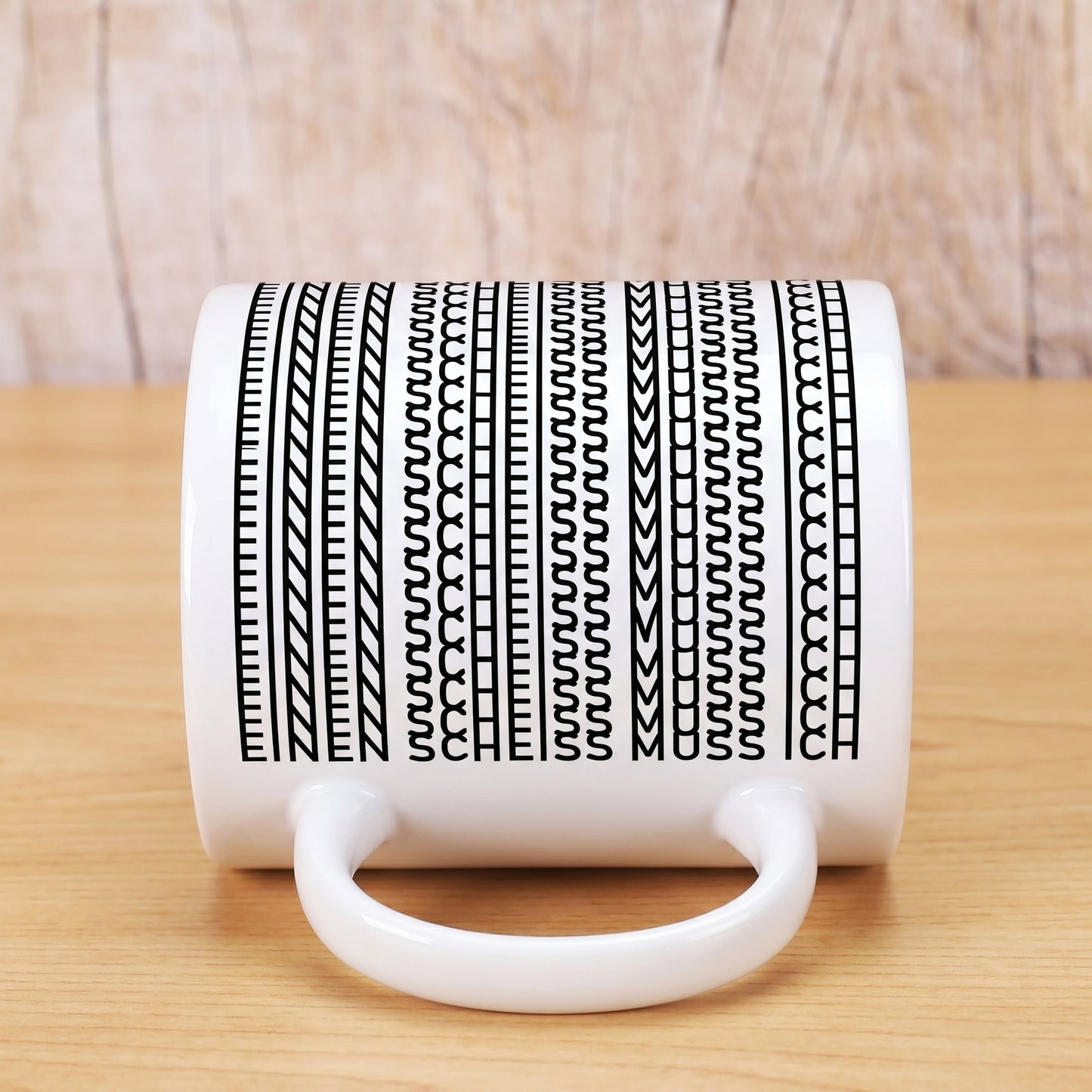 Kaffeetasse liegend mit Muster, in dem der Spruch „Einen Scheiss muss ich“ versteckt ist