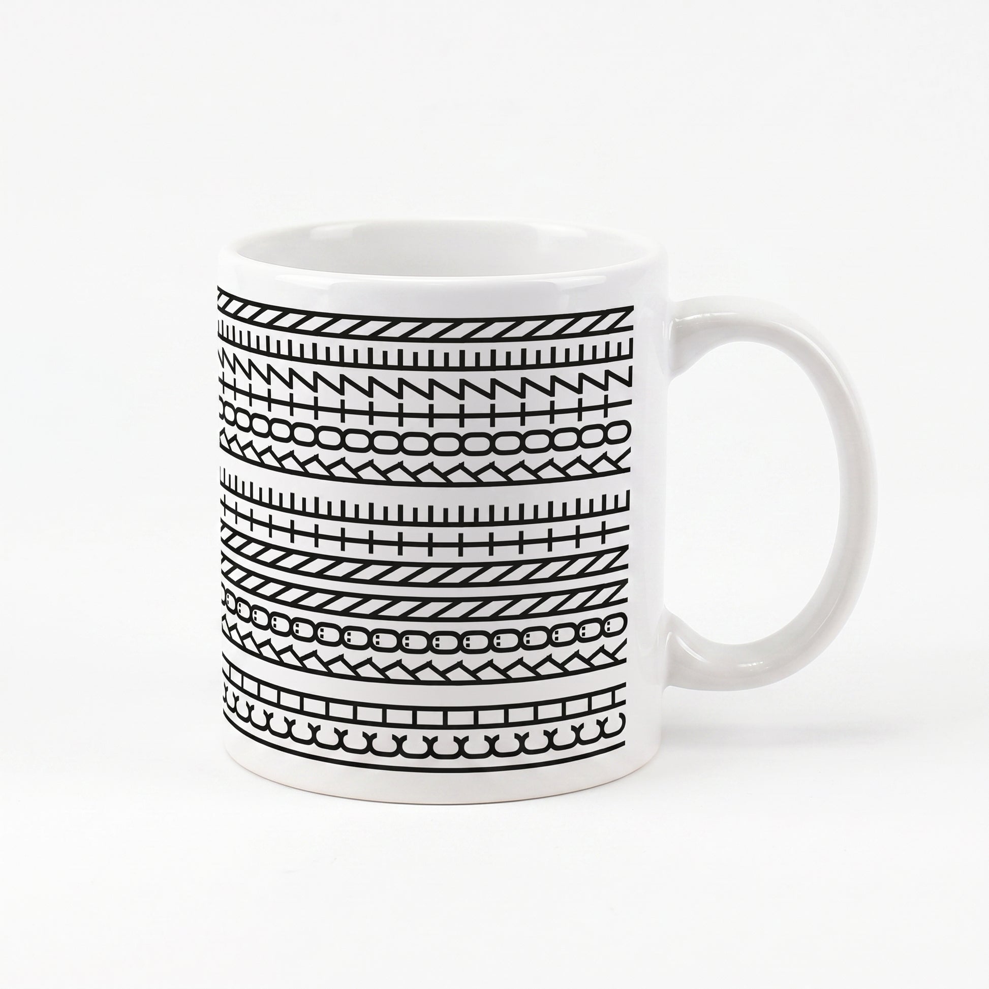 Kaffeetasse mit schwarzem Muster und versteckter Botschaft „Ich könnte kotzen“ auf weißem Hintergrund