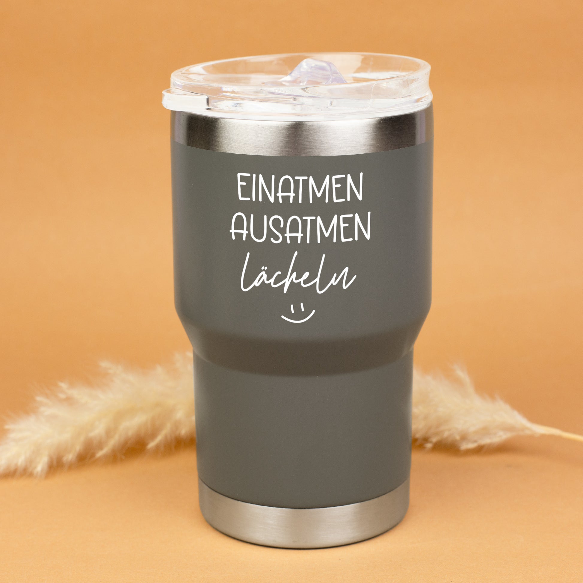 Grauer Thermobecher mit transparentem Deckel und dekorativen Trockenblumen