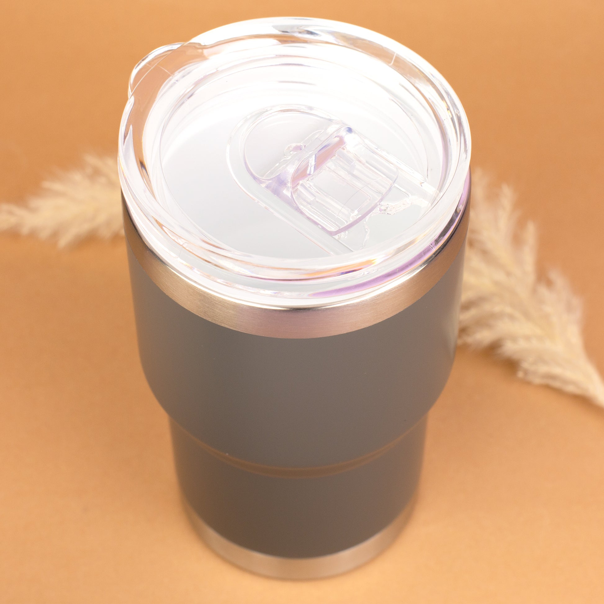 Draufsicht auf grauen Thermobecher mit transparentem Deckel und Schiebetrinköffnung