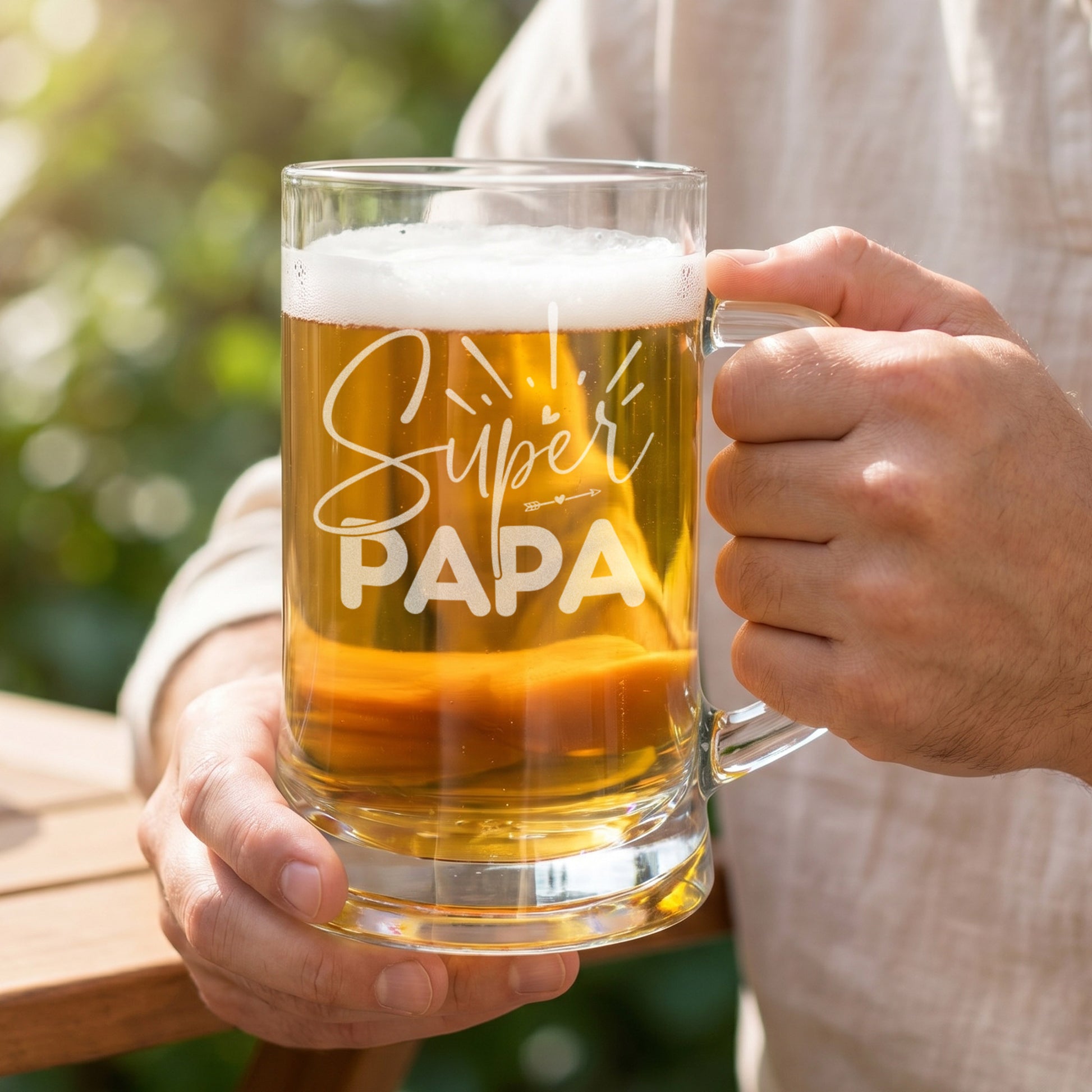 Bierseidel Super Papa mit Bier gefüllt wird in der Hand im Garten gehalten