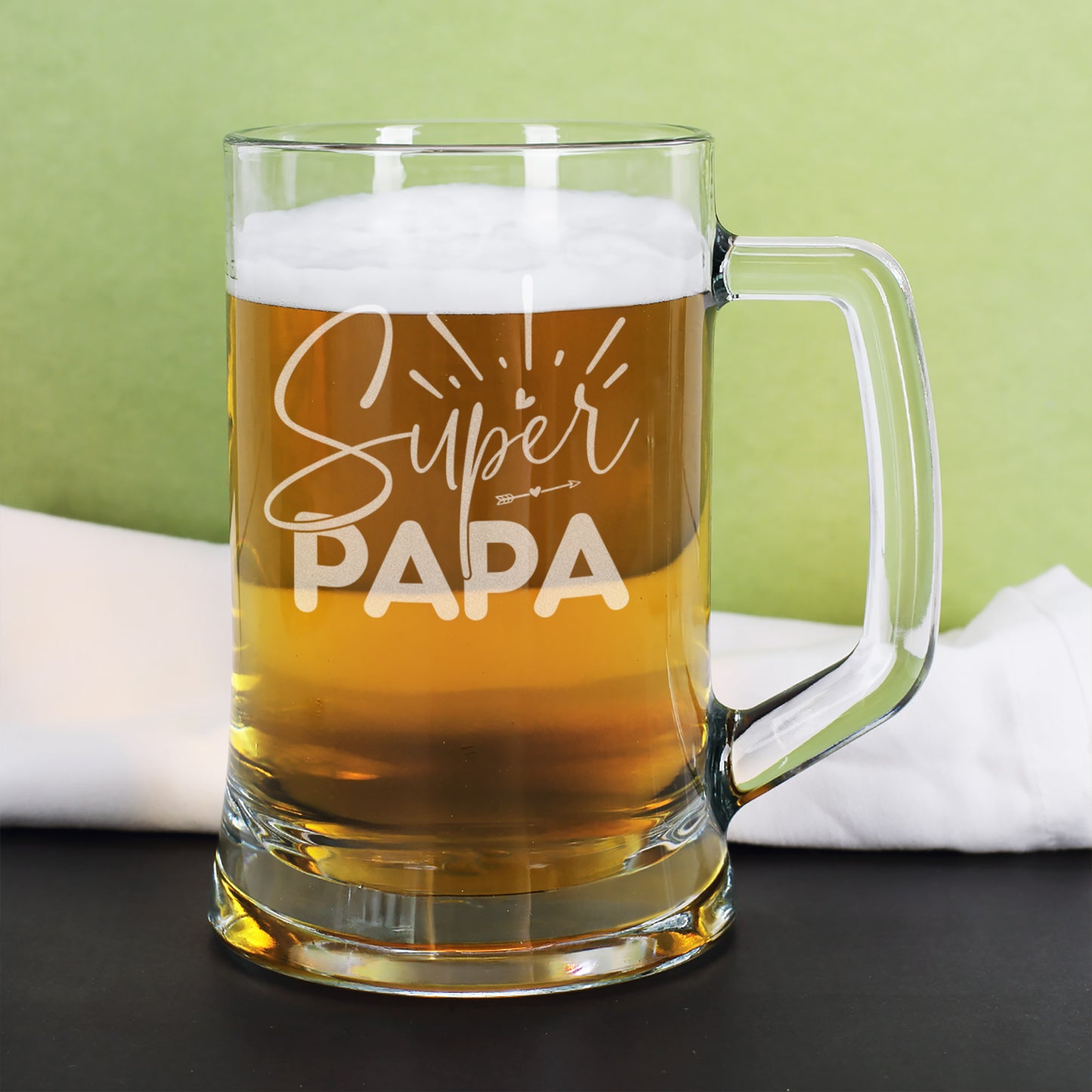 Bierkrug Super Papa mit hellem Bier und Schaum auf grünem Hintergrund