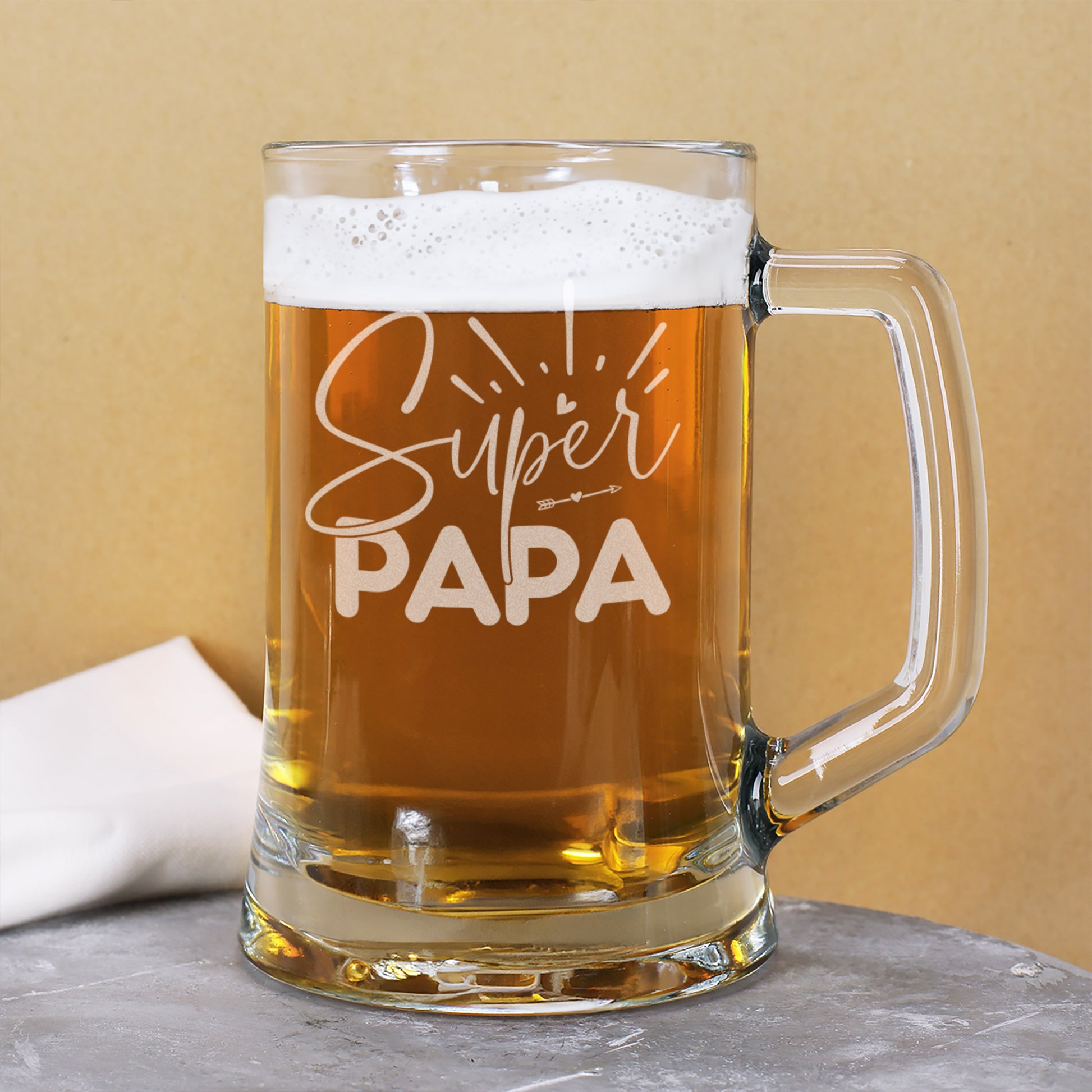 Bierseidel mit Super Papa Schriftzug auf Tisch mit Bier gefüllt