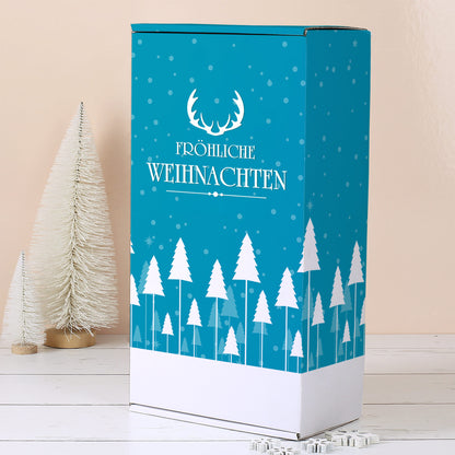 Aufrecht stehende türkise Geschenkbox mit weißem Winterwald, Schneeflocken, Geweih Motiv und Fröhliche Weihnachten Schriftzug