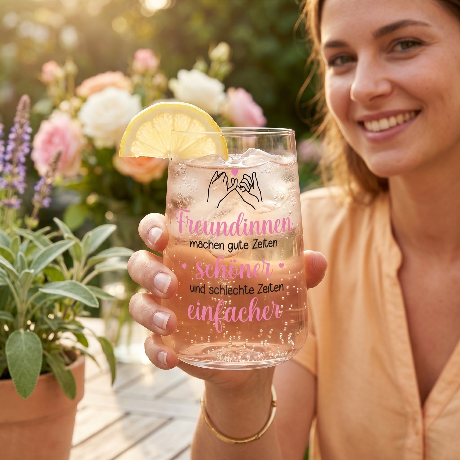 Frau hält Trinkglas mit rosa Getränk, Zitronenscheibe und Spruch über gute und schlechte Zeiten