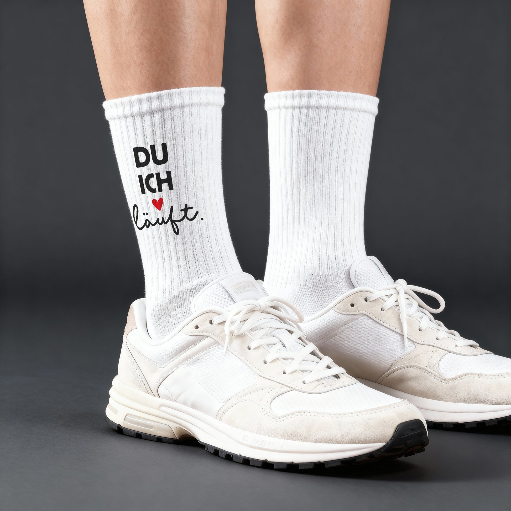 Model trägt weiße Socken mit Aufdruck „DU ICH läuft.“ und rotem Herz, kombiniert mit weißen Sneakern