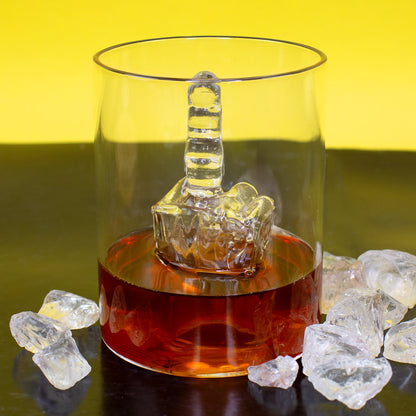 Mittelfinger Glas mit Whisky und Eiswürfeln vor gelbem Hintergrund