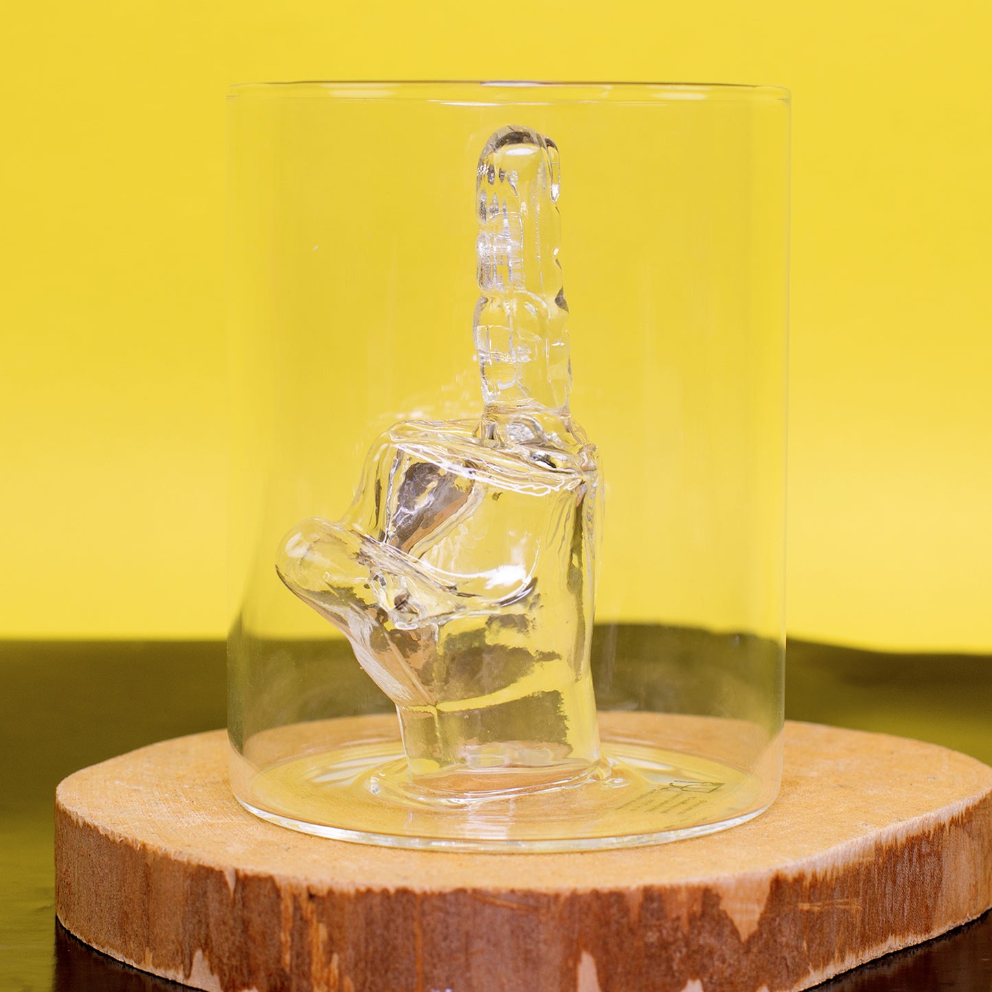 Mittelfinger Trinkglas von hinten mit klarer Glasfigur im Glasinneren