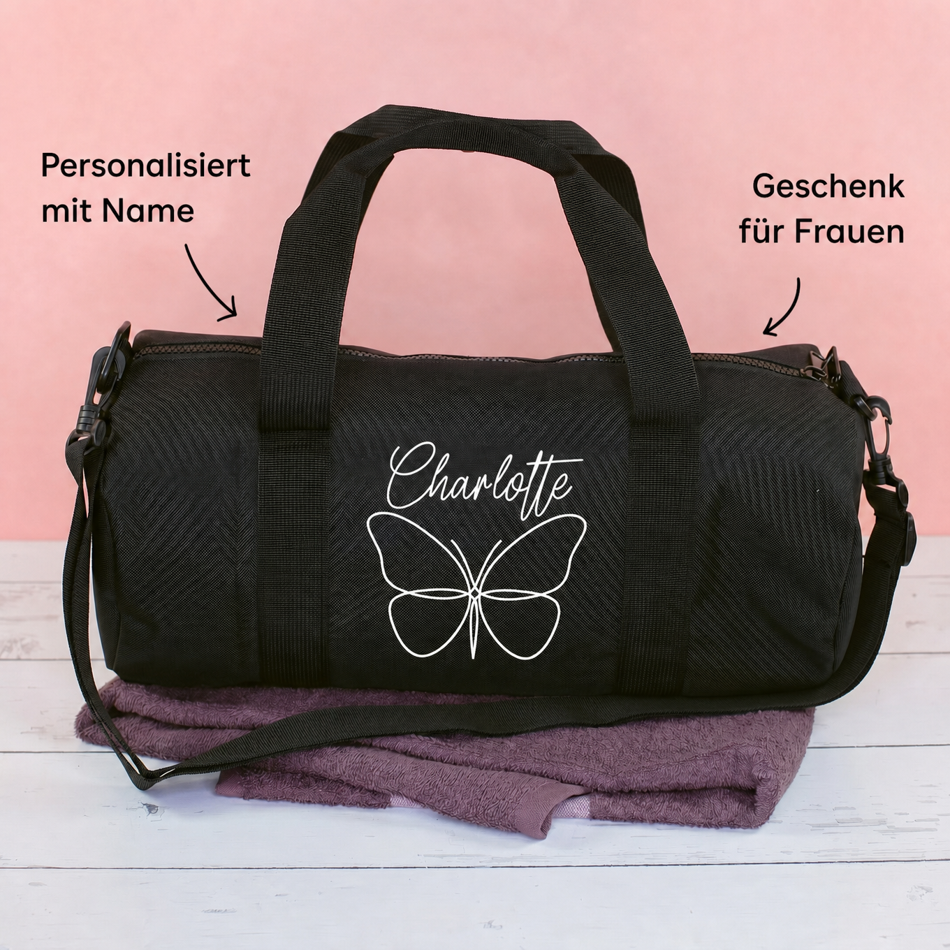 Schwarze Sporttasche mit Schmetterlingsmotiv und Name Charlotte auf rosa Hintergrund mit Produktinformationen