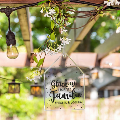 Personalisierter Acrylanhänger in Hausform mit Namen Antonia und Joshua hängt als Gartendeko im Außenbereich
