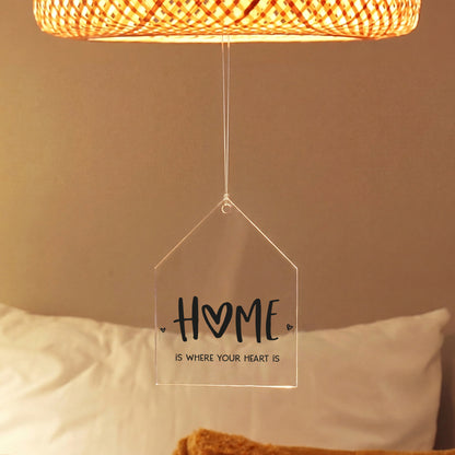 Acrylanhänger in Hausform mit HOME-Aufdruck hängt unter einer Lampe als gemütliche Dekoration für Zuhause