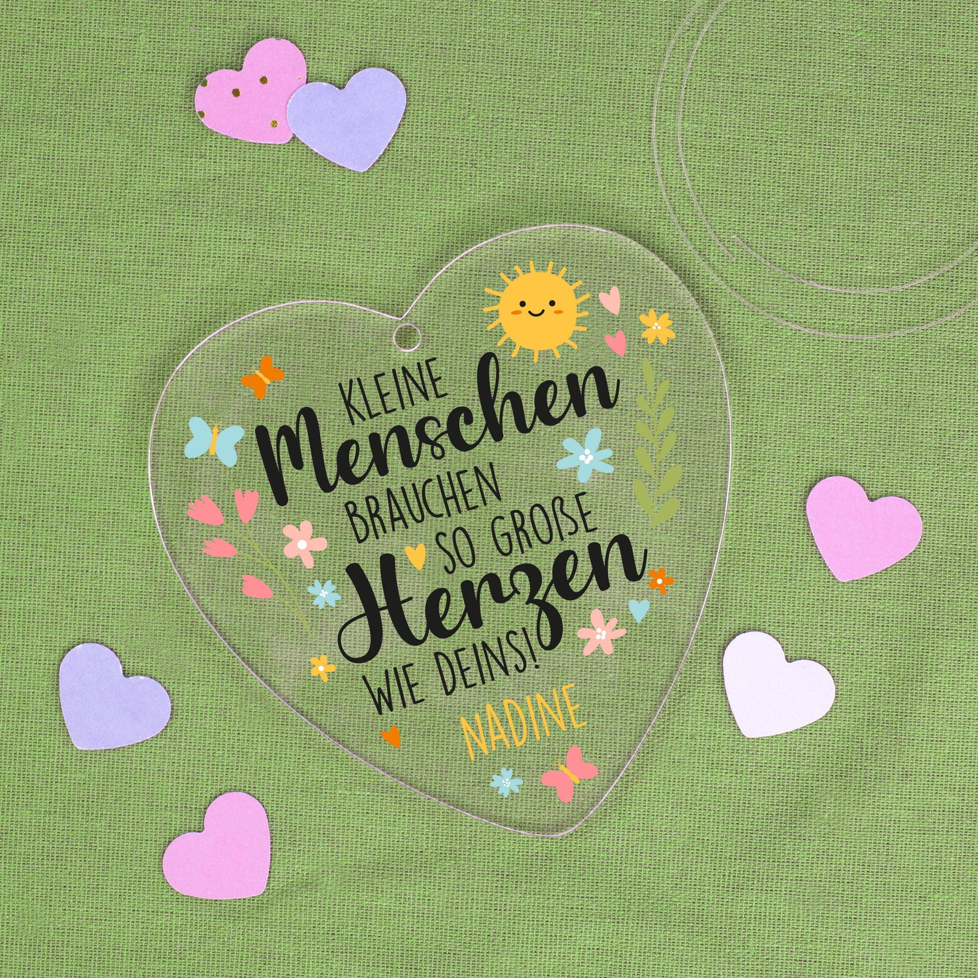 Personalisiertes Acrylherz mit Spruch und Name Nadine auf grünem Stoff mit Papierherzen