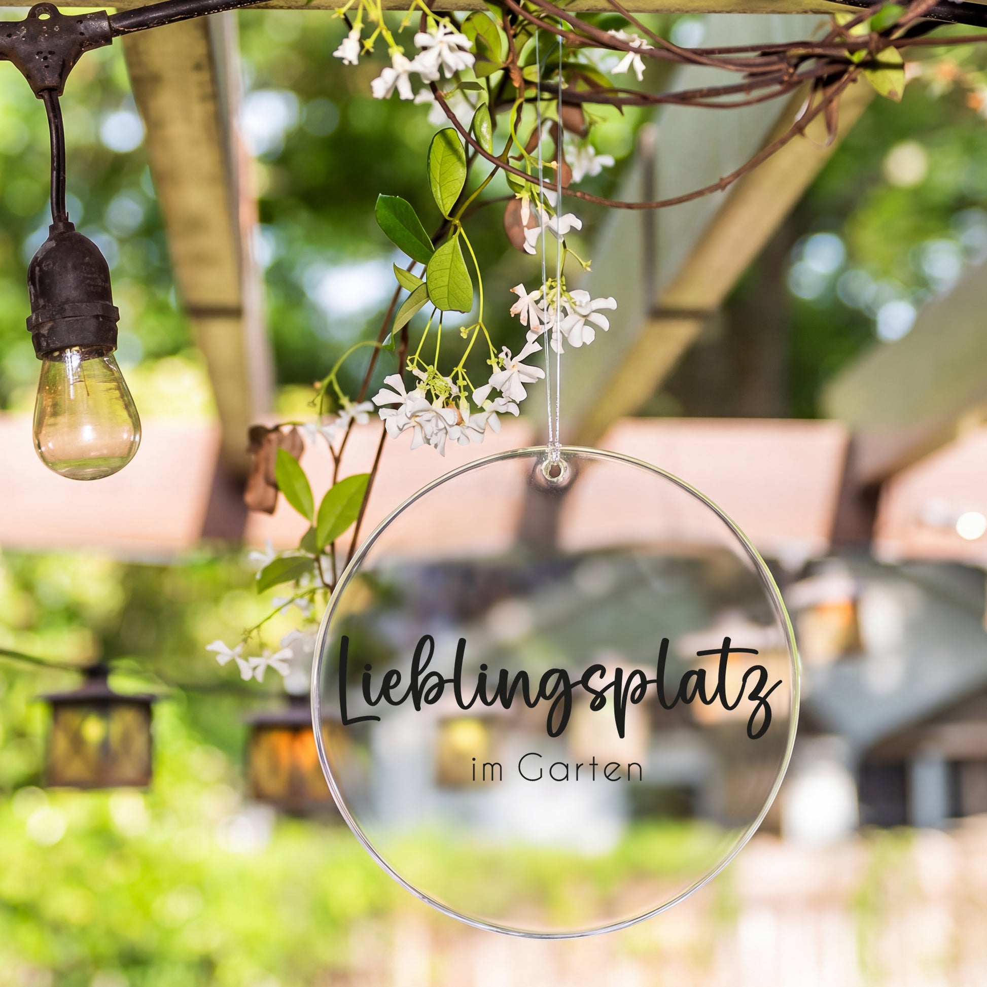 Deko-Anhänger aus Acryl mit Aufdruck Lieblingsplatz im Garten an einer überdachten Terrasse aufgehängt