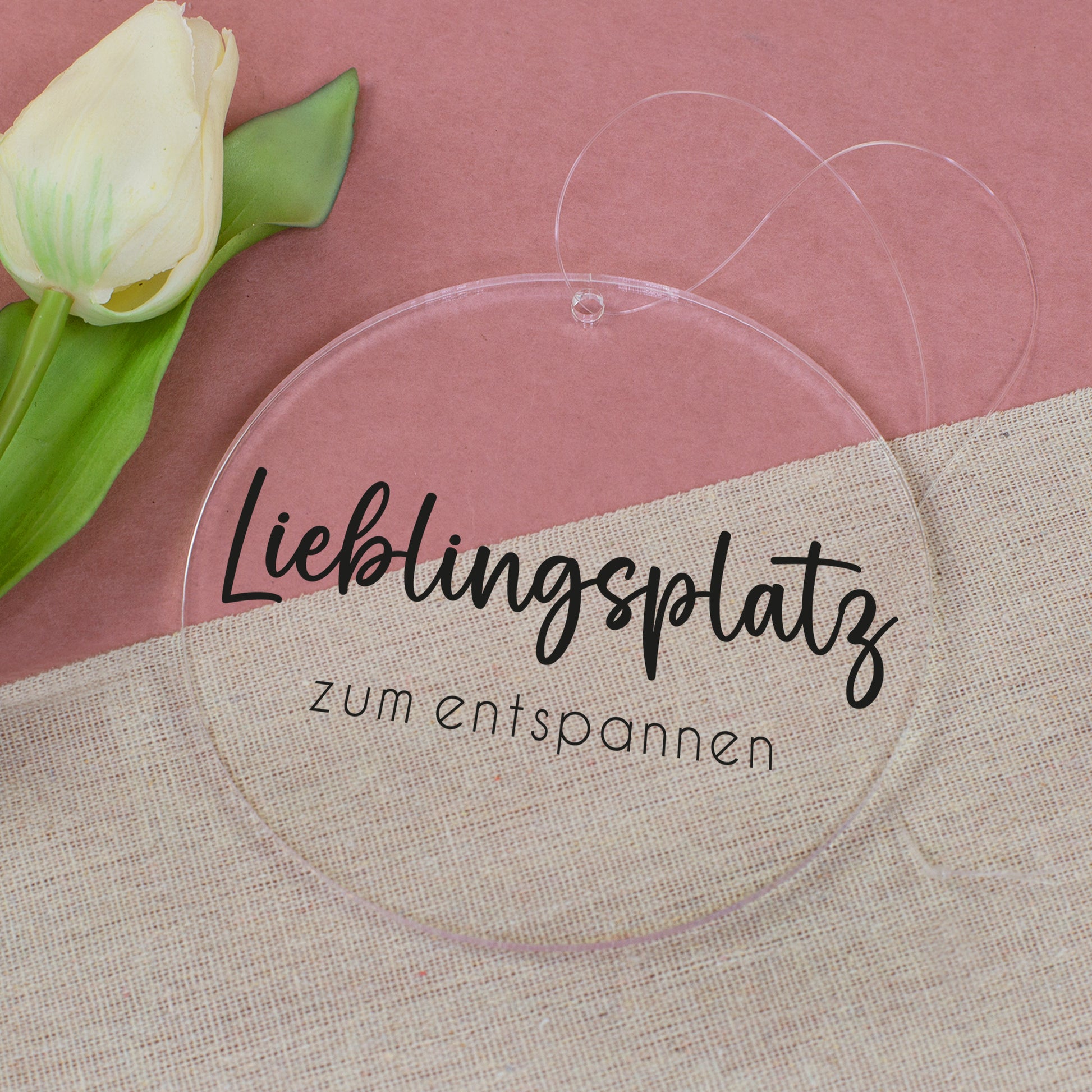 Runder Deko-Anhänger aus Acryl mit Aufdruck Lieblingsplatz zum entspannen neben Tulpe auf Stoffunterlage