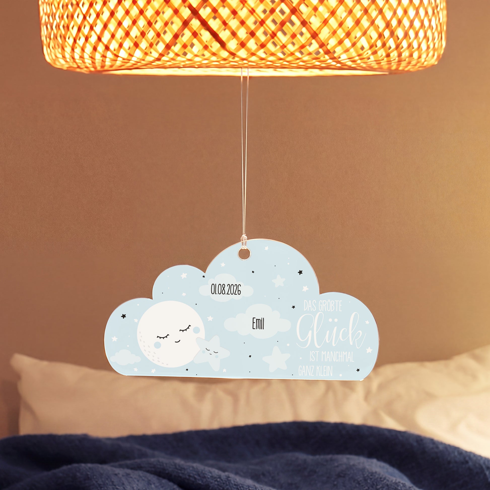 Personalisierter Acryl Wolken Anhänger zur Geburt eines Jungen mit Name Emil und Datum unter einer Lampe im Babyzimmer