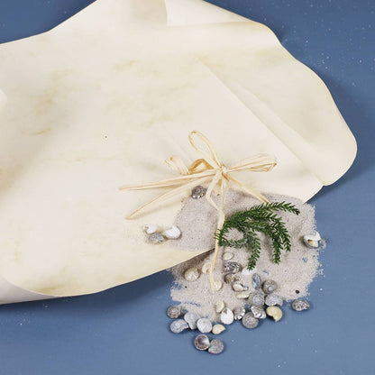 Füllung der romantischen Flaschenpost samt Muscheln, Papier, Grün und Sand