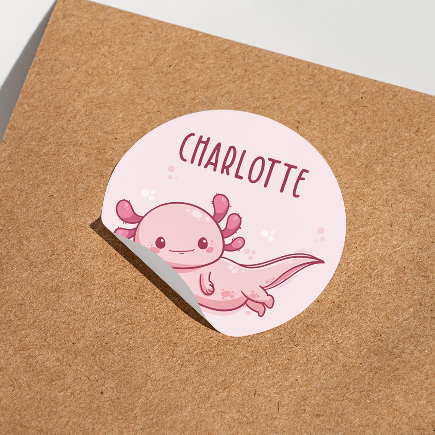 Runder Namensaufkleber mit Axolotl Motiv und Name Charlotte auf Karton
