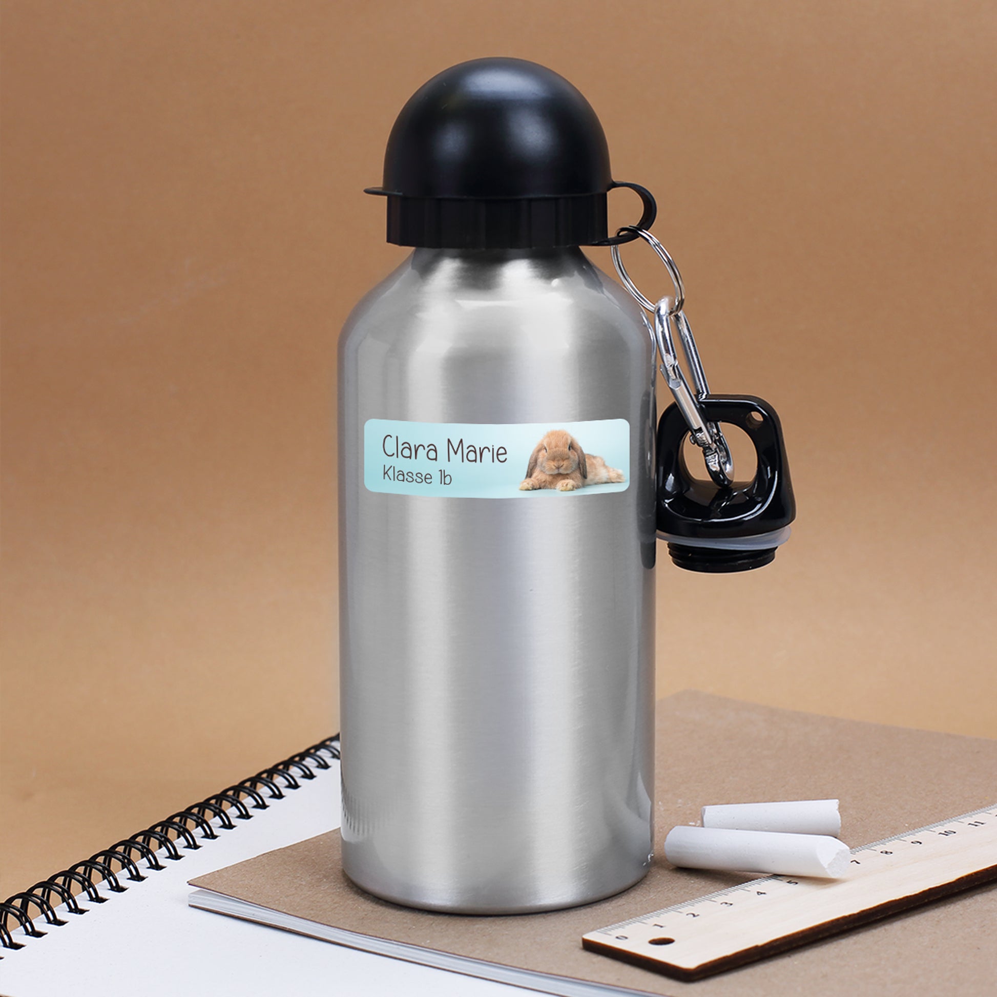 Silberne Trinkflasche mit personalisiertem Namensaufkleber Clara Marie Klasse 1b und niedlichem Hase Motiv