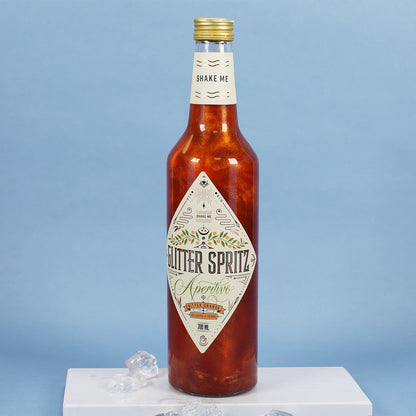 Glitter Spritz Flasche in Nahaufnahme auf blauem Hintergrund mit Eiswürfeln dekoriert