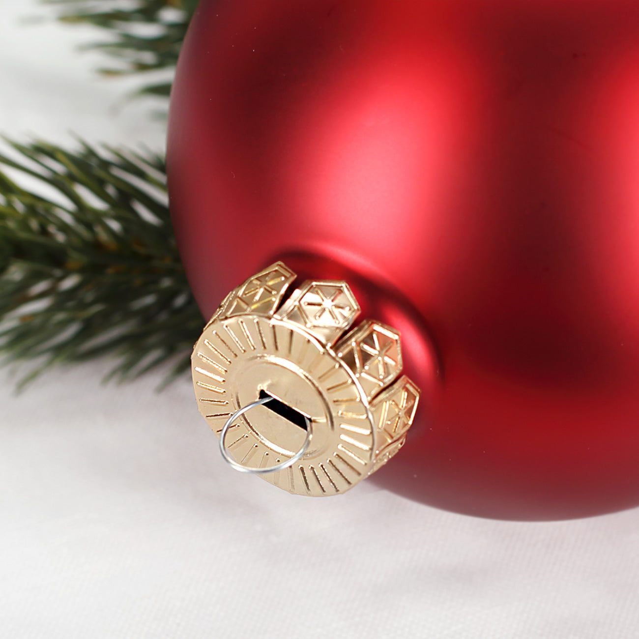 Detailaufnahme rote glänzende Christbaumkugel mit goldener Aufhängekappe