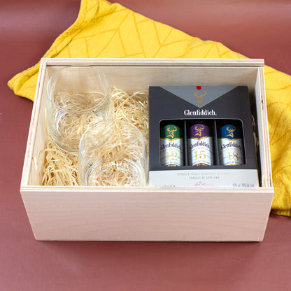 Geöffnete Holzbox für personalisiertes Whisky-Geschenkset mit Whiskygläsern, Holzwolle und Glenfiddich Tasting Set