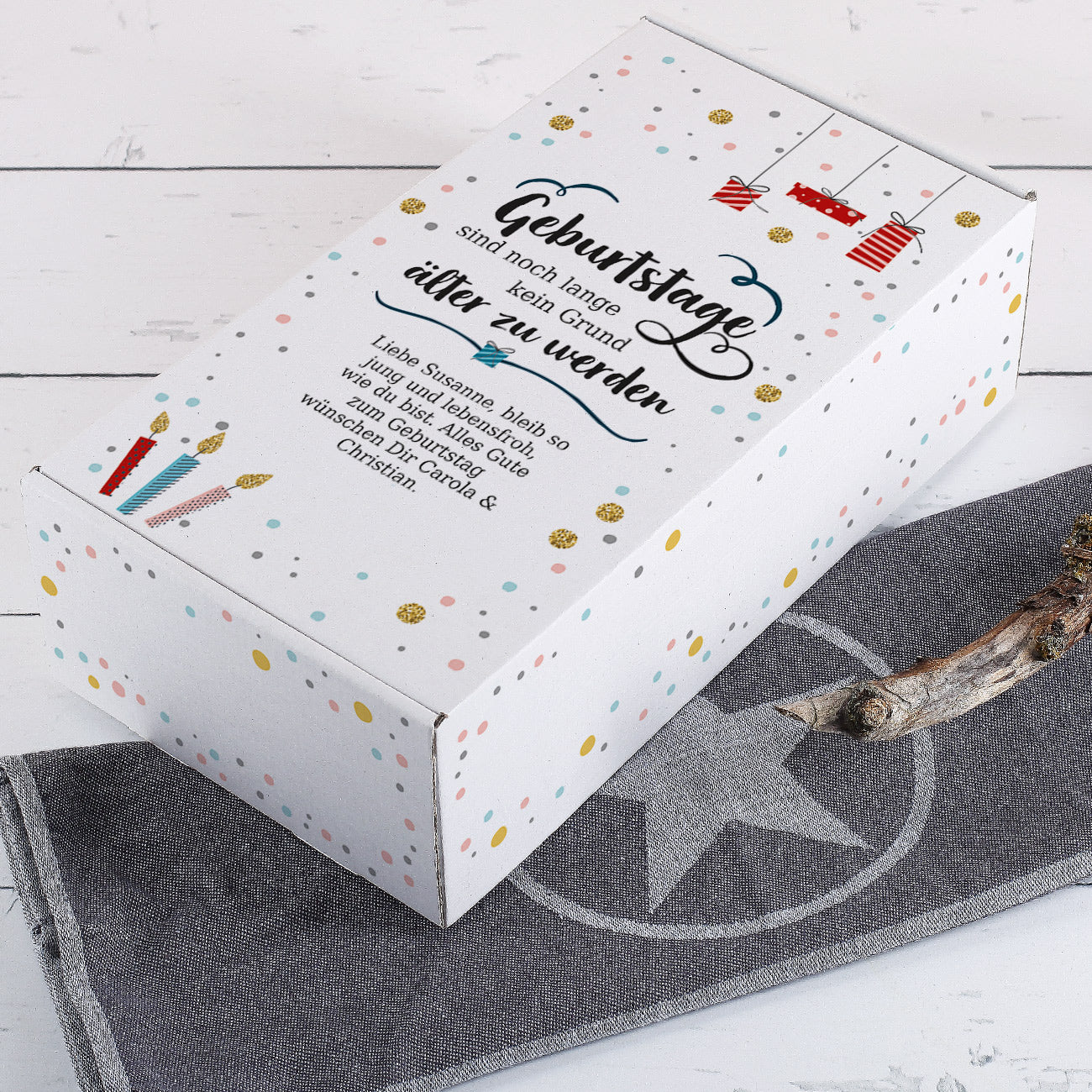 Geschenkbox aus Pappe mit Aufdruck "Geburtstage sind noch lange kein Grund älter zu werden" und Wunschtext