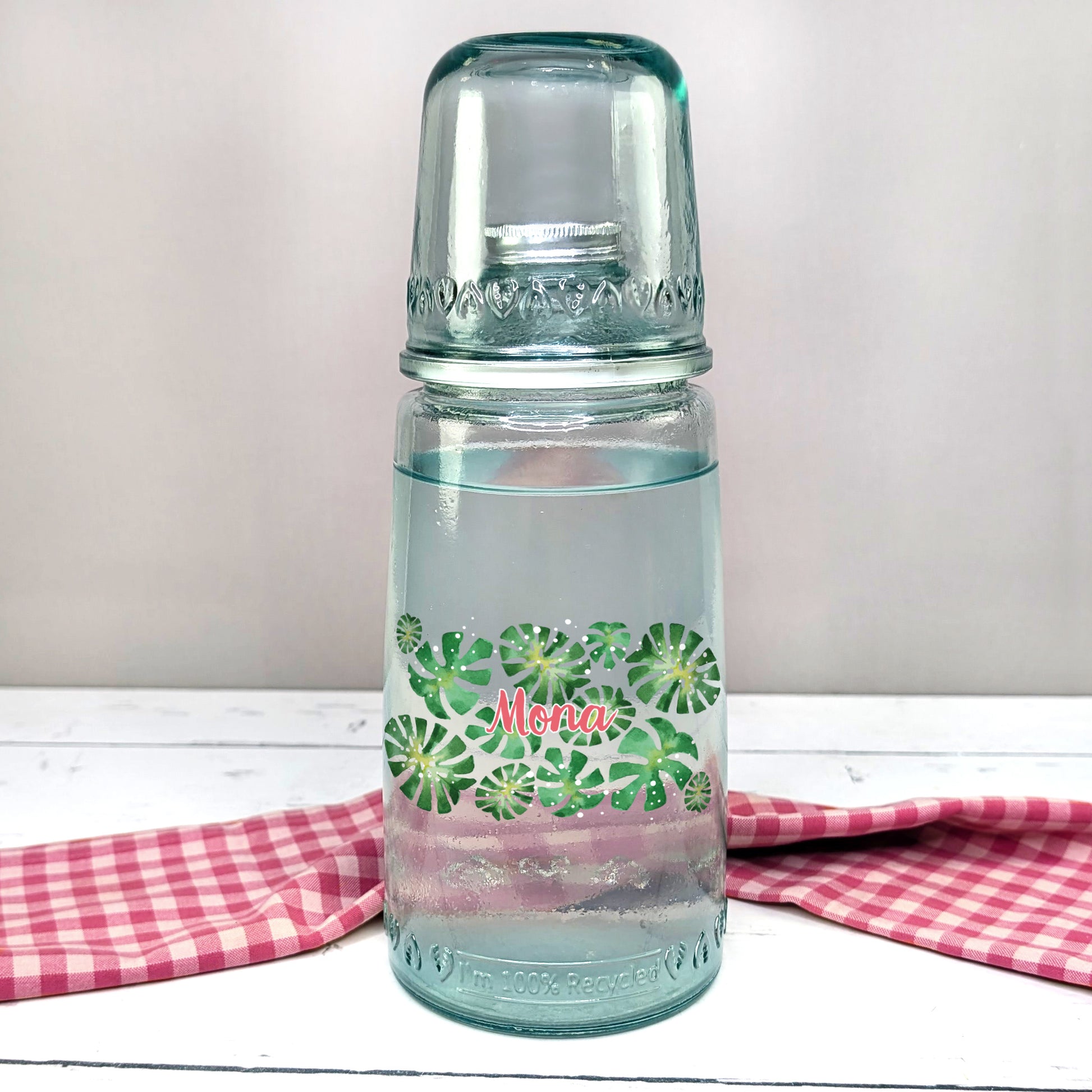 Personalisierte Karaffe mit Monstera-Motiv und Name – frontal auf Tisch