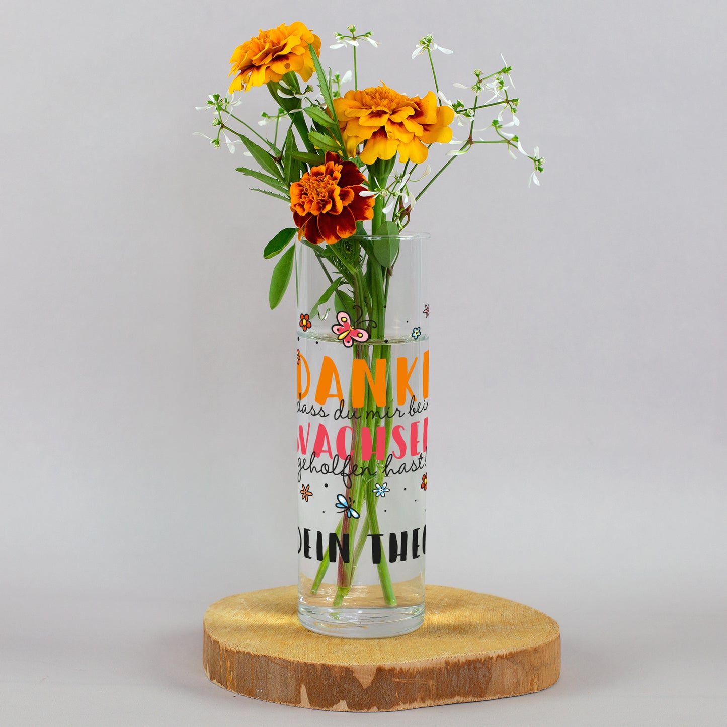 Kleine Glasvase mit Danke fürs Wachsen Motiv und orangefarbenem Blumenstrauß als Geschenk für Erzieherin