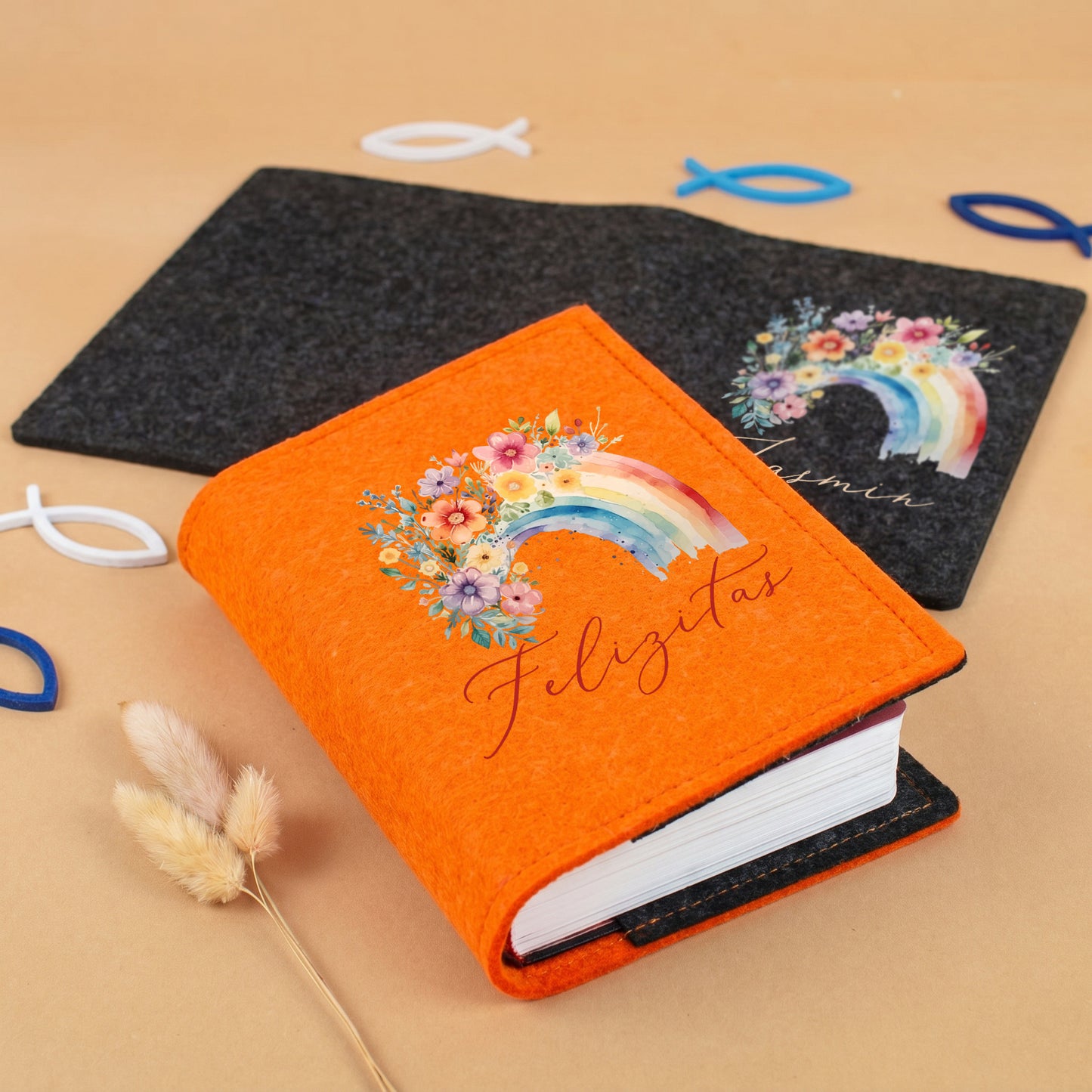 Personalisierte Buchhülle aus orangefarbenem Filz mit Regenbogen-Motiv, Blumen und Name für Gotteslob oder Gesangbuch