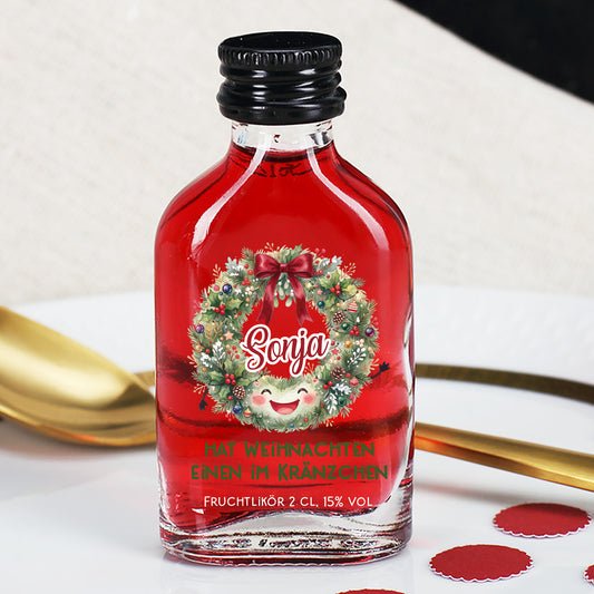 Roter Fruchtlikör mit Weihnachtskranz und Name Sonja als personalisiertes Weihnachtsgeschenk auf festlich gedecktem Tisch