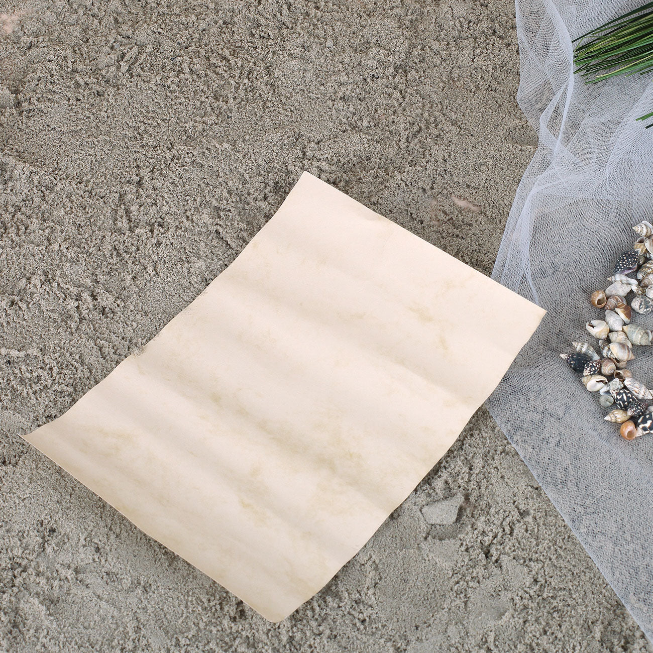 Flaschenpost Geschenkidee mit Glasflasche, Brief und maritimer Dekoration auf Sand