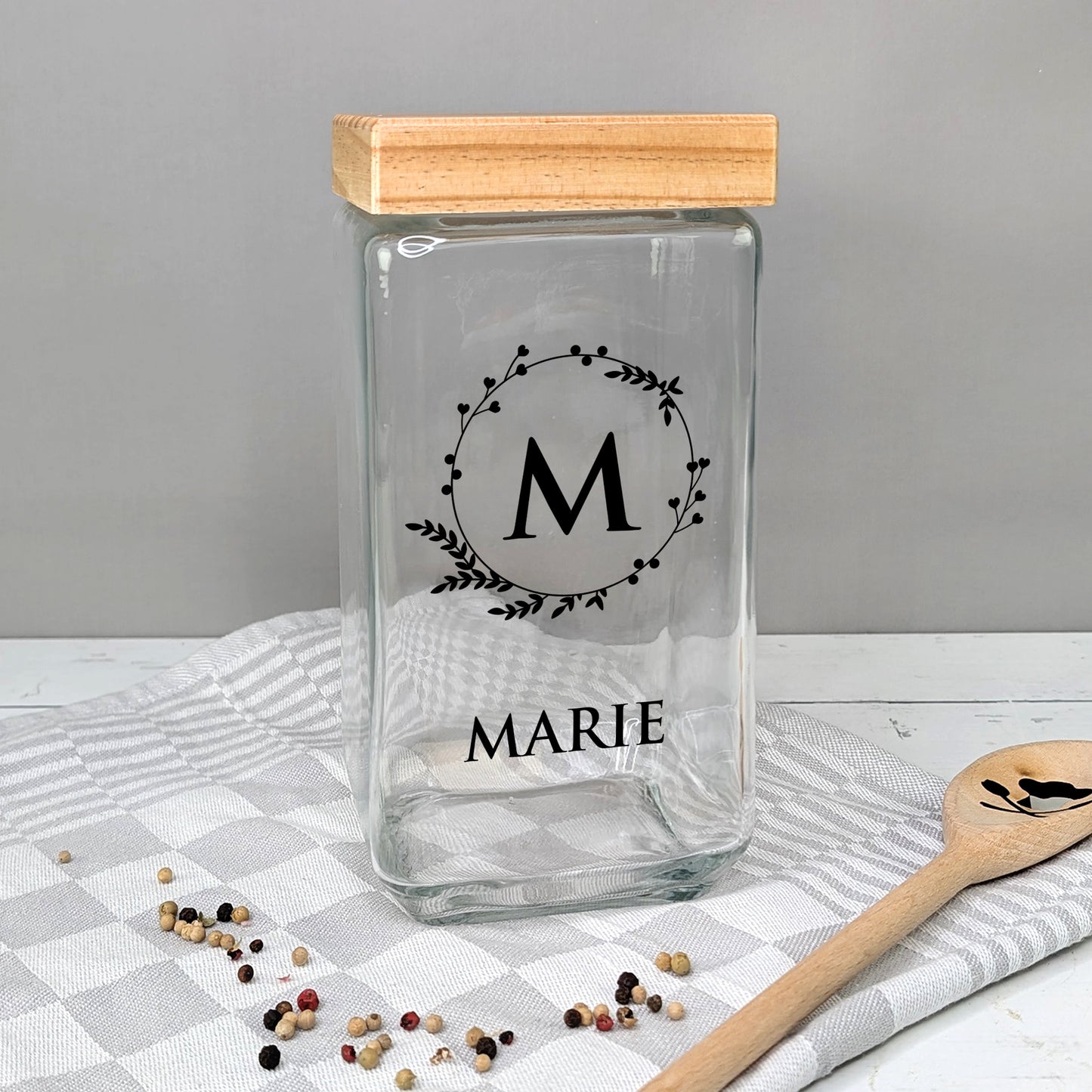 Glasvorratsbehälter mit Initiale „M“ und Name „MARIE“, auf Tisch mit Geschirrtuch