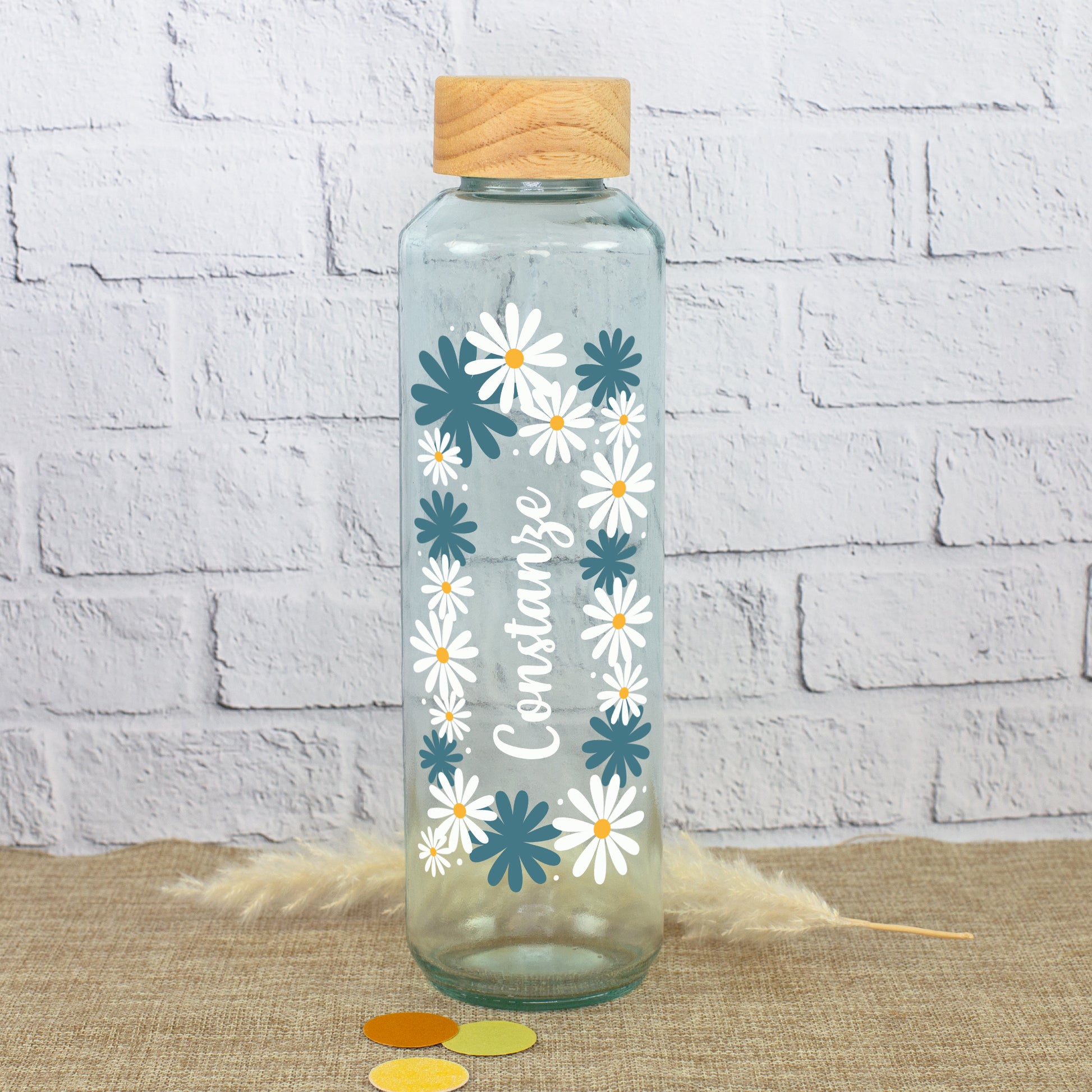 Handgearbeitete Glas Trinkflasche mit Holzdeckel, Blumenkranz und Name Constanze auf natürlichem Hintergrund