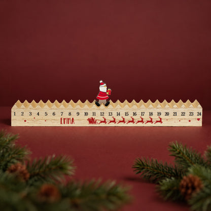 Personalisierter Holz-Adventskalender mit Wunschnamen, Zahlen 1 bis 24 und beweglichem Weihnachtsmann auf der oberen Kalenderleiste