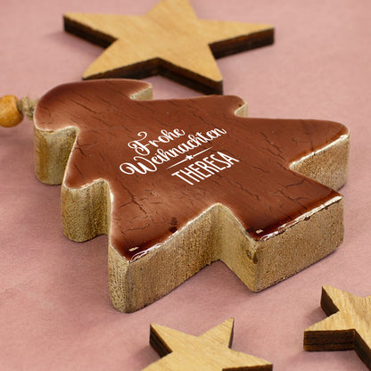 Personalisierter Holz-Tannenbaum mit Aufdruck „Frohe Weihnachten Theresa“ liegend zwischen dekorativen Holzsternen