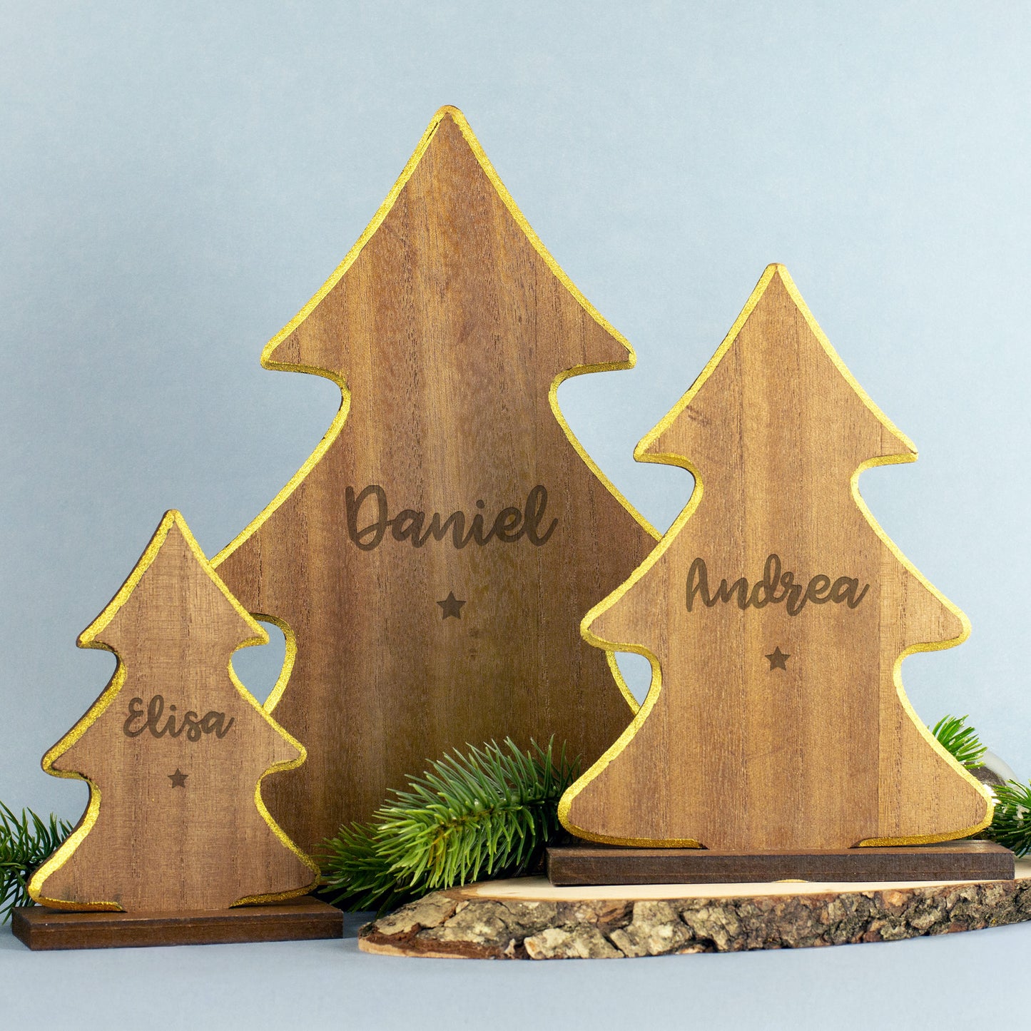 Holzengel mit goldfarbenem Rand und Gravur „Andrea“, darunter ein kleiner eingravierter Stern, stehend auf Holzsockel vor weißem Hintergrund.