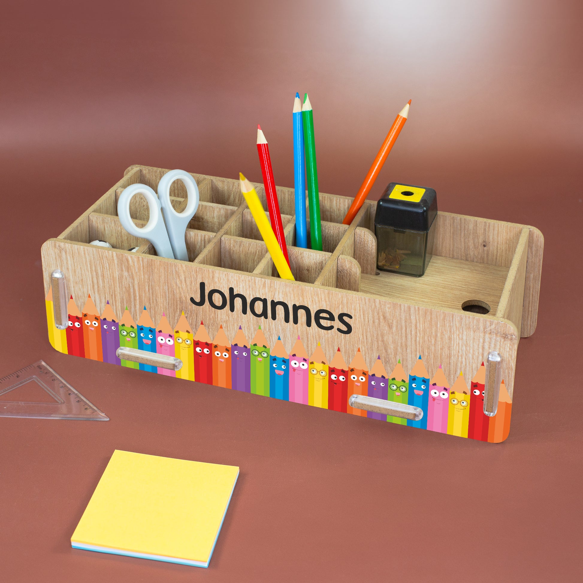 Stiftebox in Holzoptik mit Name Johannes und buntem Stiftemotiv auf dem Schreibtisch