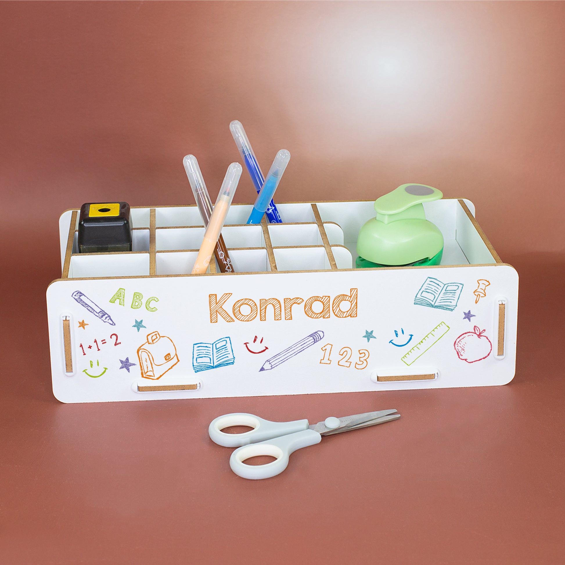 Personalisierte weiße Stiftebox mit Name Konrad und buntem Schuldesign, gefüllt mit Stiften und Schreibtischzubehör