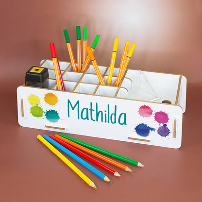 Personalisierte weiße Stiftebox mit Name Mathilda und bunten Farbklecksen, gefüllt mit Stiften und Schulzubehör