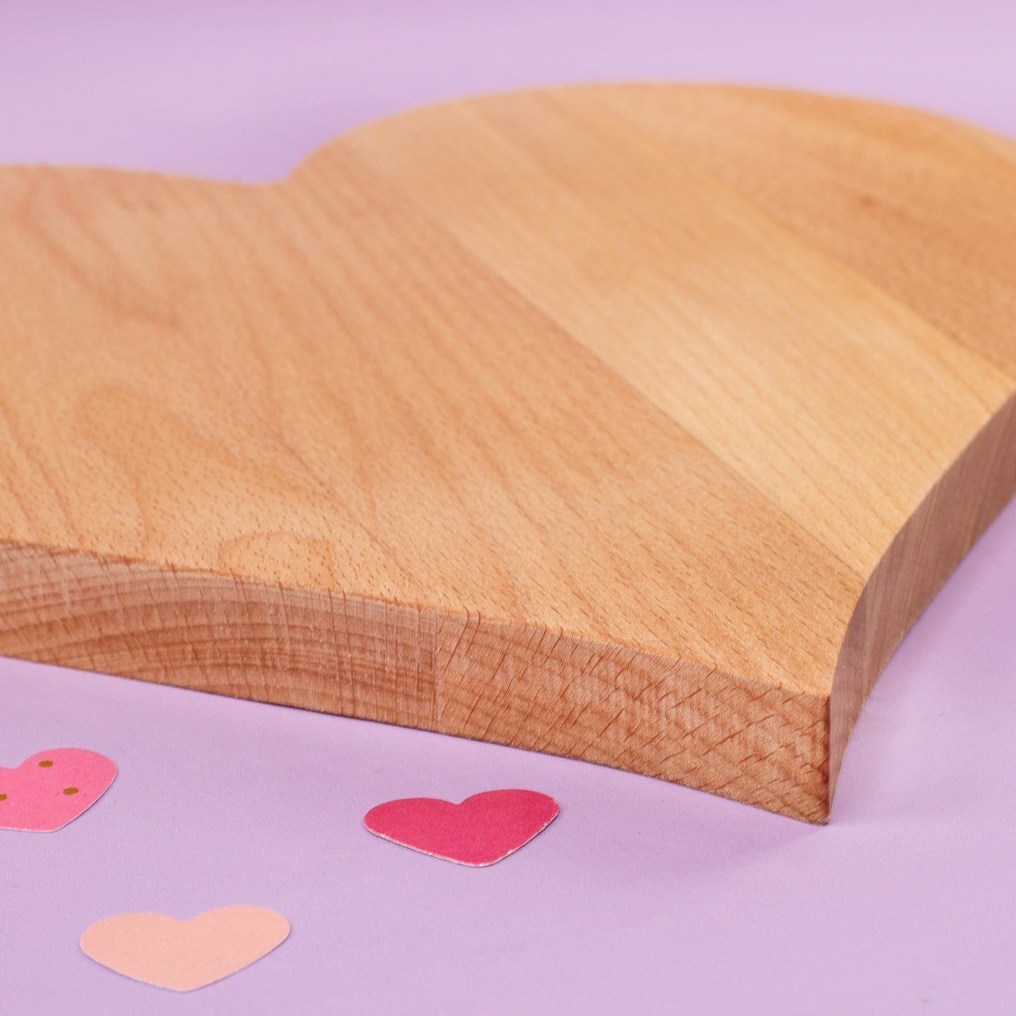 Detailaufnahme der Gravur auf dem Herz-Servierbrett aus Holz – Ringmotiv und Hochzeitsdatum