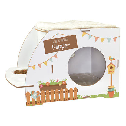 Freigestelltes weißes Katzenhaus mit Gartenmotiv, Wunschtext Hier herrscht Pepper, runder Öffnung, zwei Näpfen und Kuschelkissen