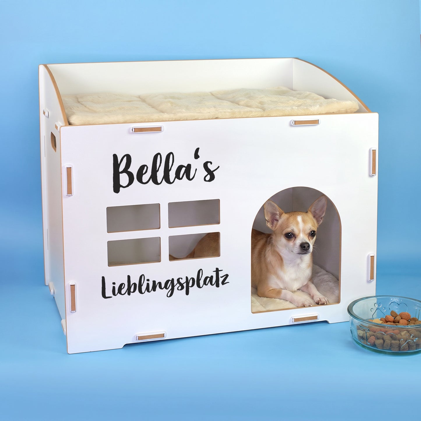 Weißes Katzenhaus mit personalisiertem Namen Bella’s, Wunschtext Lieblingsplatz und kleinem Hund in der Türöffnung